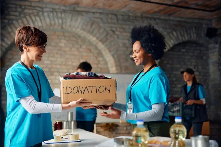 Happy volunteers cooperating while packing don.webp